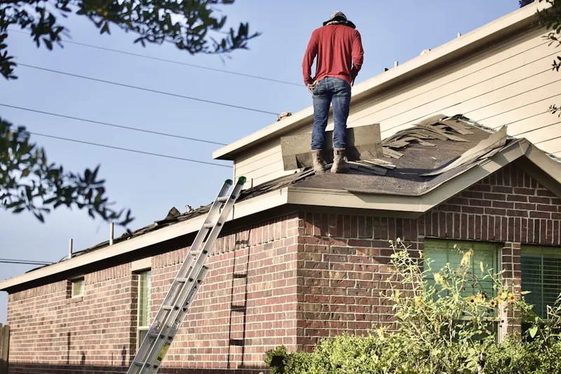 Professional roofer working on a residential roof in Savoy